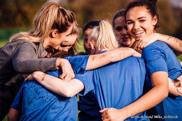 7 Mädchen umarmen sich beim Sport als Team und haben Spaß